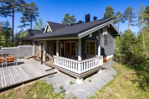 a small house with a porch and a deck at Himos Huili 1 in Jämsä