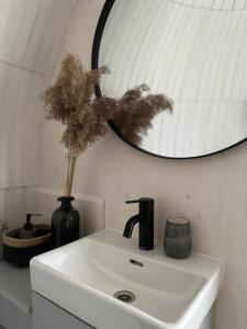 um lavatório branco com um vaso preto e um espelho em Pedaspä Igloo House and Sauna em Pedaspea