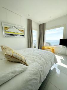 - une chambre blanche avec un grand lit et une fenêtre dans l'établissement Can Sabatilla, à Cadaqués
