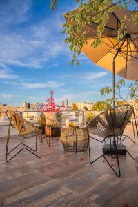 a group of chairs and an umbrella on a deck at H177 Hotel in Campeche