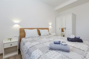 a bedroom with a large bed with blue towels on it at Apartman Sandra in Malinska