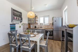 a kitchen with a table and chairs and a refrigerator at Apartman Sandra in Malinska