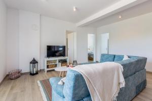 a living room with a blue couch and a tv at Apartman Sandra in Malinska +34 photos