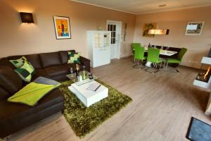 - un salon avec un canapé brun et une table dans l'établissement Ferien_HAUS LIMERICK, à Göhren-Lebbin
