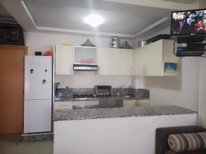 cocina con armarios blancos y nevera blanca en Olablanca Sidi rahal, en Casablanca