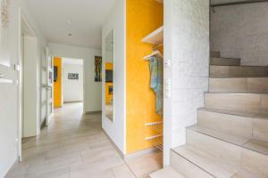 ゲーレン・レビンにあるLuxus_Ferien_VILLA AMICIのオレンジ色の壁の家の階段付きの廊下