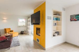 ein Wohnzimmer mit einem TV an der Wand in der Unterkunft Luxus-Ferien-VILLA AMICI in Göhren-Lebbin