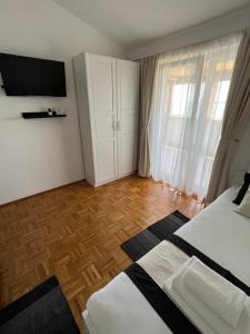 a bedroom with a bed and a television on the wall at Apartments Loncar-near Zrće beach in Novalja
