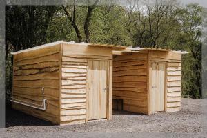 dos cobertizos de madera sentados uno al lado del otro en Ty Llewelyn Glamping & Camping, en Llanidloes