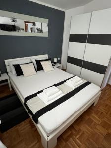 a bedroom with a large bed with black and white stripes at Apartments Loncar-near Zrće beach in Novalja