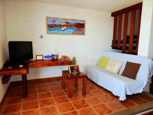 a living room with a bed and a tv at Apartamento Vacacional Pescaito en Playa Quemada in Playa Quemada