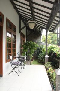 um pátio com uma mesa e cadeiras e um tecto de madeira em Bed and Breakfast Tomang em Jacarta