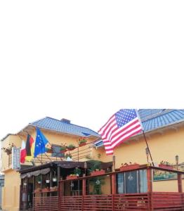a building with two flags on top of it at Pensiunea Pelican in Tulcea