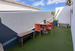 een klein balkon met een tafel en stoelen bij Ballito Backpackers in Ballito