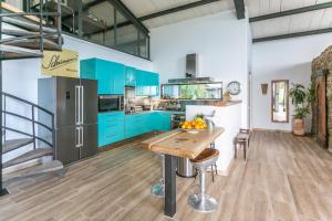 a kitchen with blue cabinets and a wooden table at Villa Tarifa Lodge in Tarifa