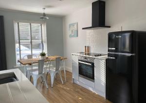 a kitchen with a black refrigerator and a table at ‘The Loft’ - Apartment by the sea in Combe Martin