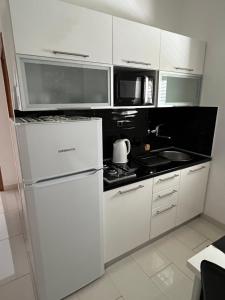 a white kitchen with a stove and a refrigerator at Apartments Loncar-near Zrće beach in Novalja