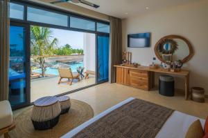 a bedroom with a bathroom with a view of the ocean at Aldiana Club Zanzibar Kwanza in Kizimkazi