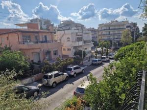 een groep auto's geparkeerd op een straat met gebouwen bij Lemon tree house Alimos marina by AthenianKeys in Athene