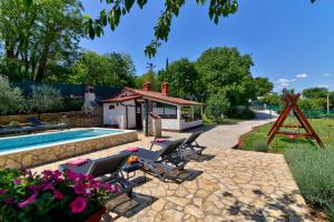 einen Pool mit Liegestühlen und ein Haus in der Unterkunft Piccola Casa - a little paradise in Kršan