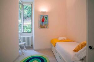 a small bedroom with a bed and a window at Villa Vescovo Appartamento con accesso al lago in Orta San Giulio