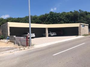 a garage with cars parked in it next to a road at Apartments Loncar-near Zrće beach in Novalja