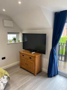 ein Wohnzimmer mit einem Flachbild-TV an der Wand in der Unterkunft Robin's Nest - a self contained detached annex with sky sports & movies in Newborough