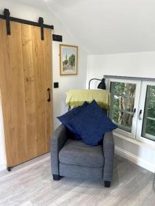 a chair in a room with a window and a door at Robin's Nest - a self contained detached annex with sky sports & movies in Newborough