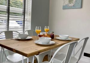 a wooden table with two glasses of orange juice at ‘The Loft’ - Apartment by the sea in Combe Martin