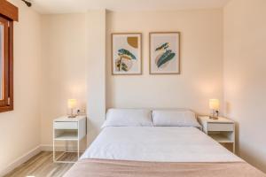 ein Schlafzimmer mit einem Bett und zwei Nachttischen in der Unterkunft Hanami Estepona Centro 3A in Estepona