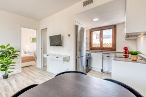 eine Küche und ein Wohnzimmer mit einem Tisch und einem Waschbecken in der Unterkunft Hanami Estepona Centro 3A in Estepona