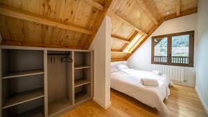 Aran Hostel في سالاردو: غرفة نوم بسريرين وسقف خشبي