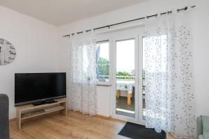 Televízia a/alebo spoločenská miestnosť v ubytovaní Apartments Oleander