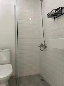 a bathroom with a toilet and a glass shower stall at Yucca Alaçatı in Alacati