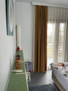 een kamer met een groen bureau en een bed bij Yucca Alaçatı in Alacati