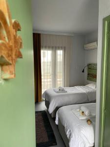 a hotel room with three beds and a window at Yucca Alaçatı in Alaçatı
