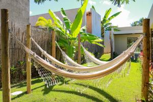a hammock in a yard next to a fence at Pousada Noah Noah Milagres in São Miguel dos Milagres