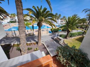 an aerial view of a resort with palm trees and a pool at Casa de Mariposas in Costa Del Silencio