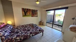 1 dormitorio con 1 cama y una gran puerta corredera de cristal en Stay Awhile in Port Pirie - min stay 4 nights, en Port Pirie