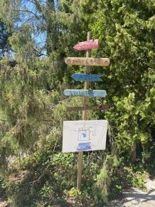 a wooden street sign with several signs on it at Le Patio Bleu in La Crau