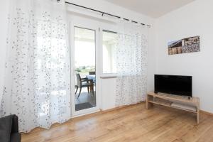 Televízia a/alebo spoločenská miestnosť v ubytovaní Apartments Oleander