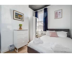 a bedroom with a white bed and a window at Central Belfast Apartments Ballyhackamore in Belfast