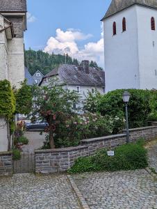 un edificio con una torre de reloj y una pared de piedra en FeWo Altstadt BL en Bad Laasphe