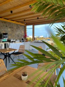 un comedor con mesa y sillas y una habitación con ventanas en Aegean Hospitality en Mykonos