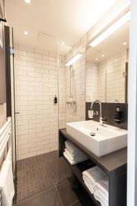 フェヒタにあるibis Styles Vechtaの白い洗面台とシャワー付きのバスルーム