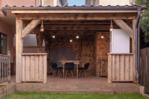 a wooden pavilion with a table and chairs on a patio at Pensiunea Grand in Eforie Nord