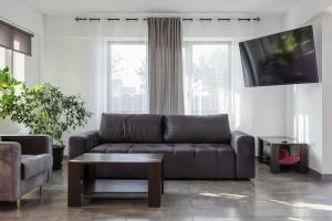 a living room with a couch and a tv at Pensiunea Grand in Eforie Nord
