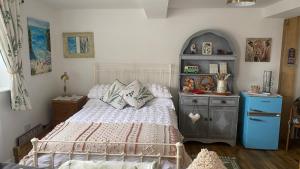 a bedroom with a bed and a blue cabinet at Wheelhouse - Grinkle Bell Cottage in Saltburn-by-the-Sea