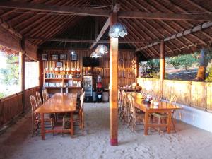 布納肯的住宿－Raja Laut Dive Resort Bunaken，大楼内的餐厅,配有木桌和椅子