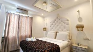 um quarto com uma grande cama branca e uma janela em Villa das Arábias Boutique Hotel em Maputo